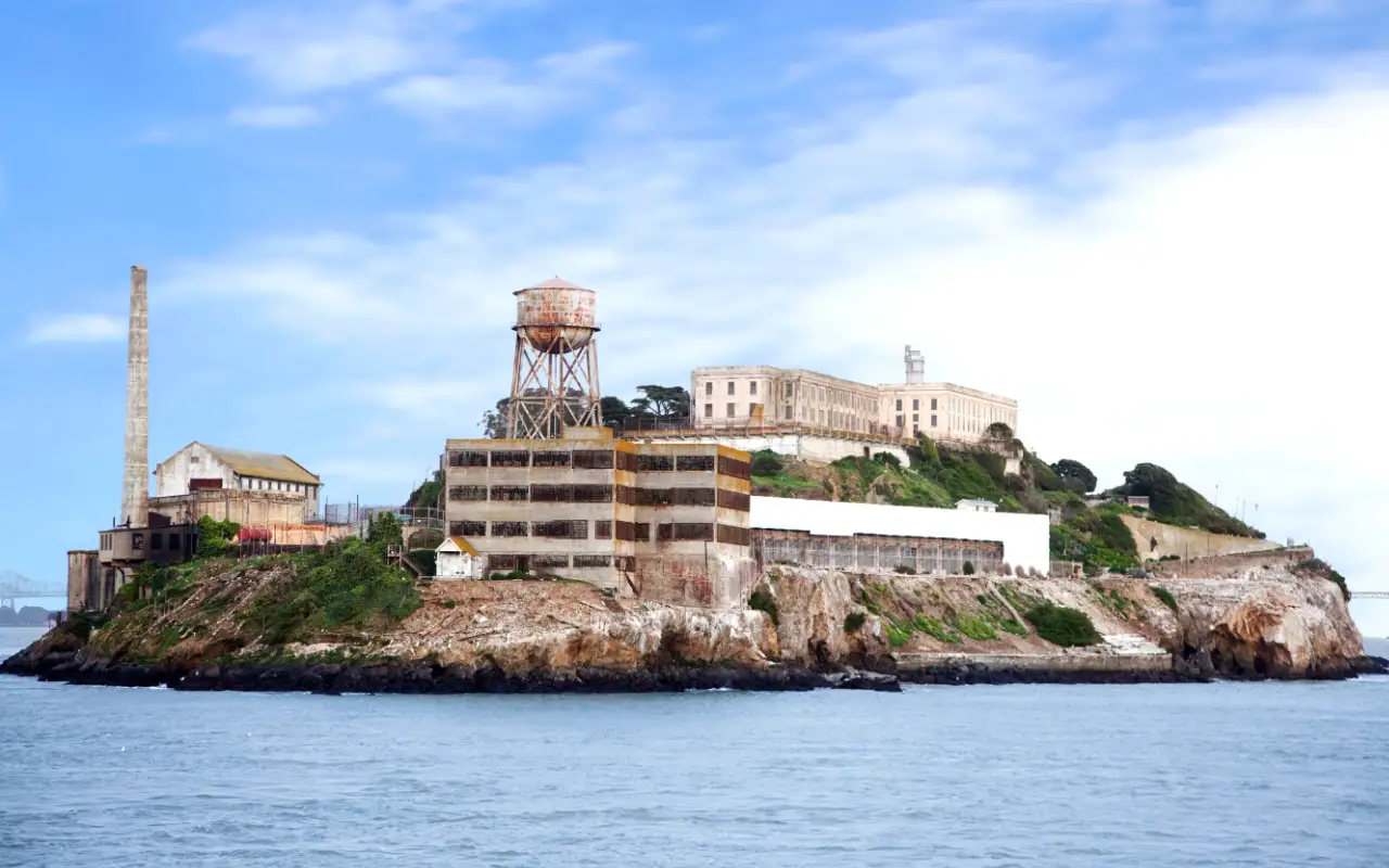 Scenic view of the historic Alcatraz Island with surrounding waters and cloudy sky