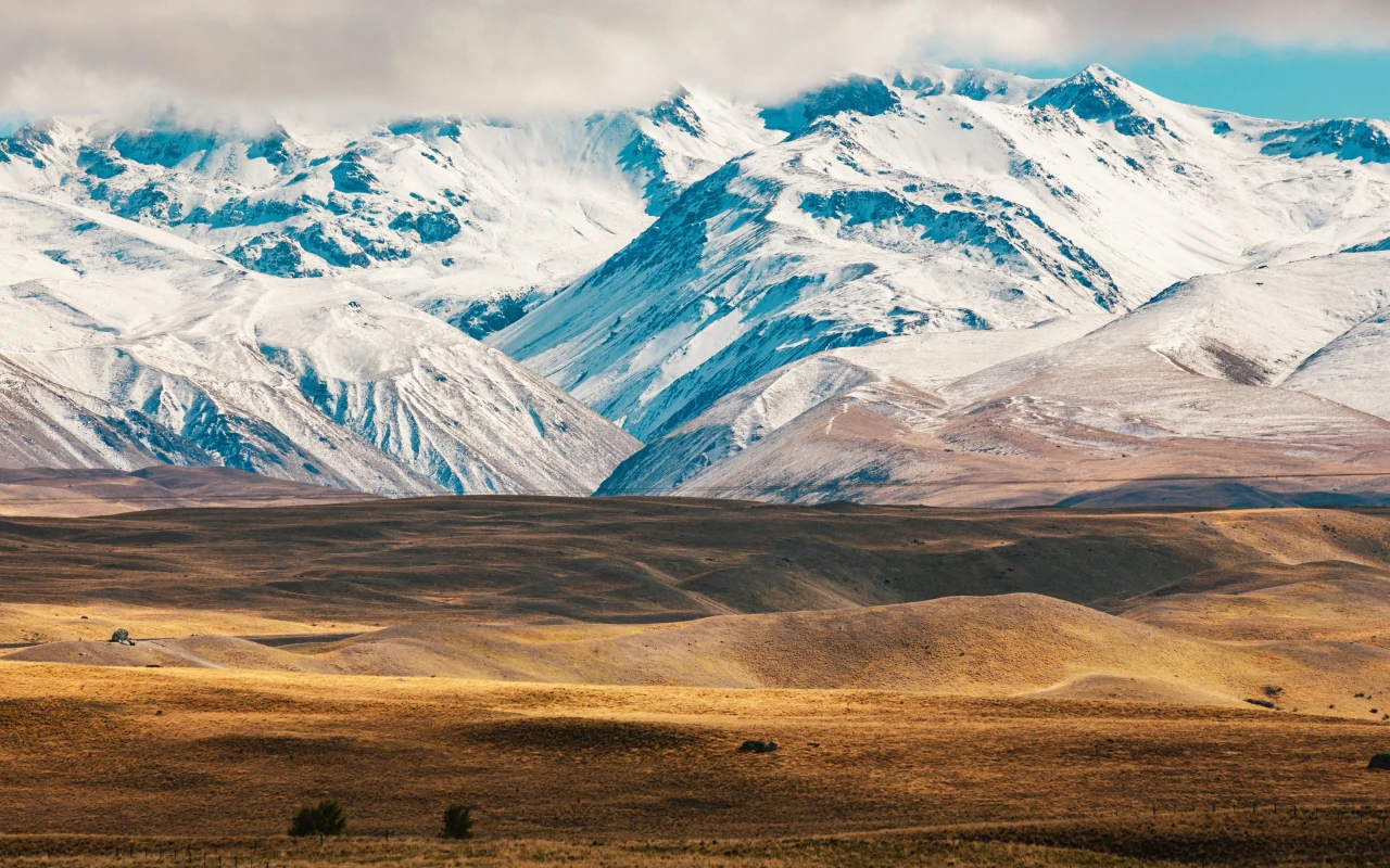 Scenic view of Aoraki Mount Cook National Park with snow-capped peaks and lush greenery