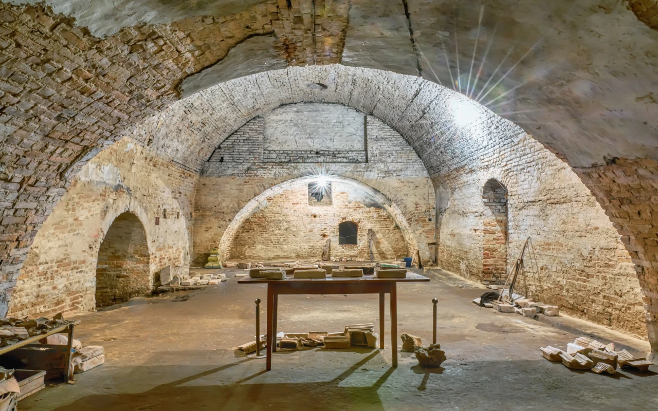 Underground tunnels of the ancient Catacombs of Rome, featuring labyrinthine passageways and tombs