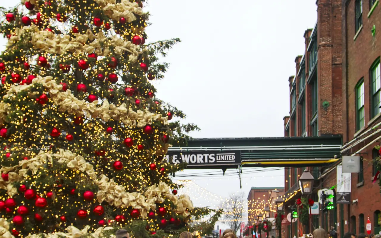 Christmas market with a beautifully decorated tree and people walking
