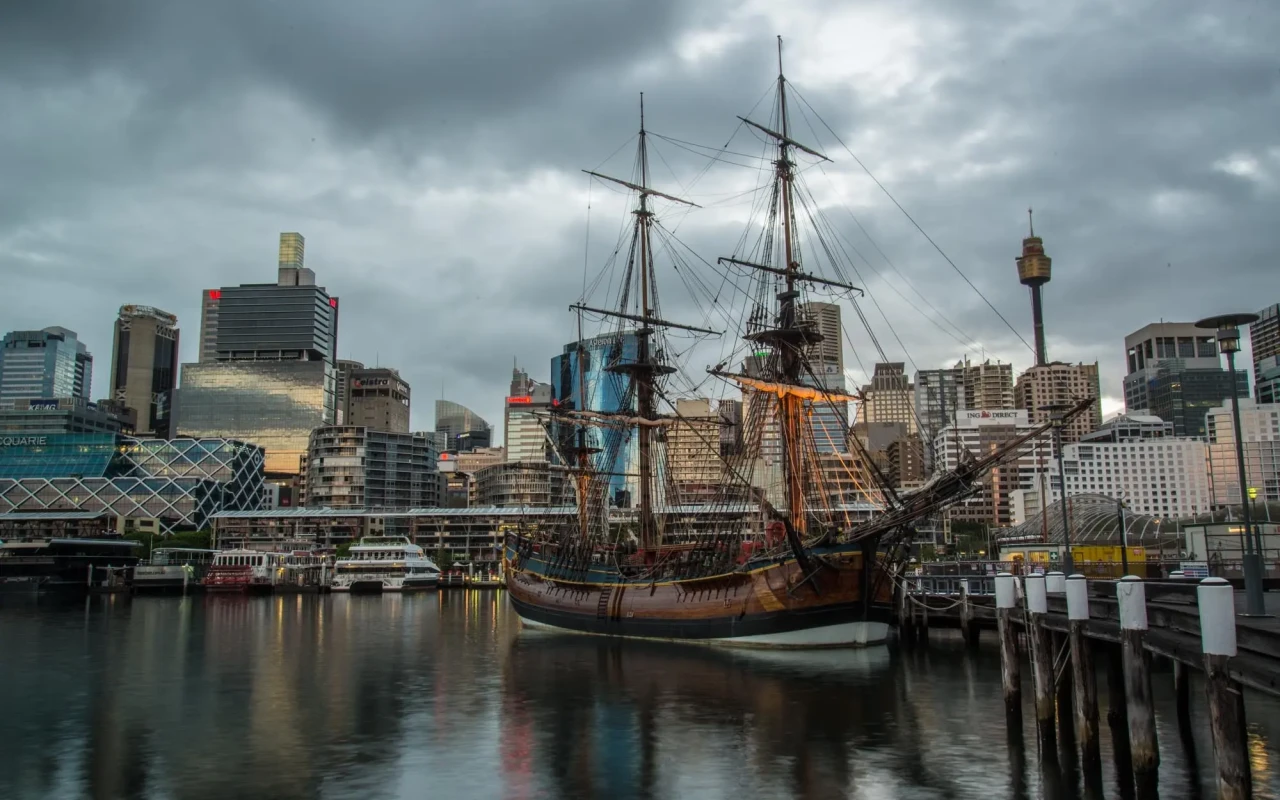 Panoramic view of Darling Harbour with its bustling waterfront, featuring boats, restaurants, and shimmering city skyline
