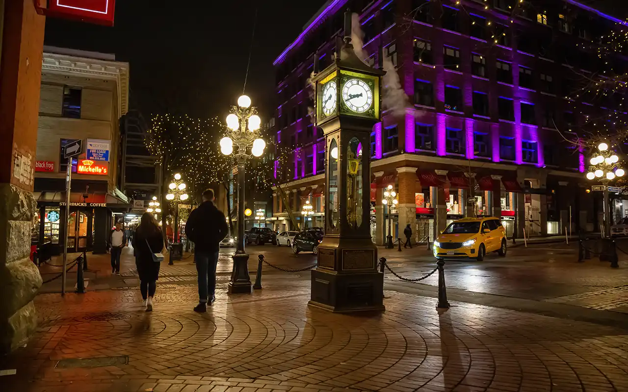 A vibrant street scene in Gastown, Vancouver, featuring historical buildings, cobblestone streets, and the iconic steam clock.