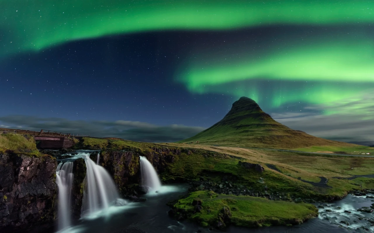 Stunning view of the northern lights dancing in the sky above the majestic Kirkjufell mountain in Iceland