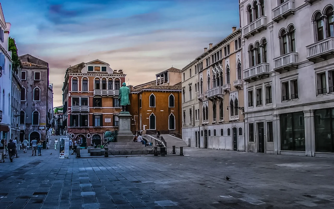 Aerial view of the bustling Piazze Venezia in daytime, showcasing the historic architecture and lively atmosphere