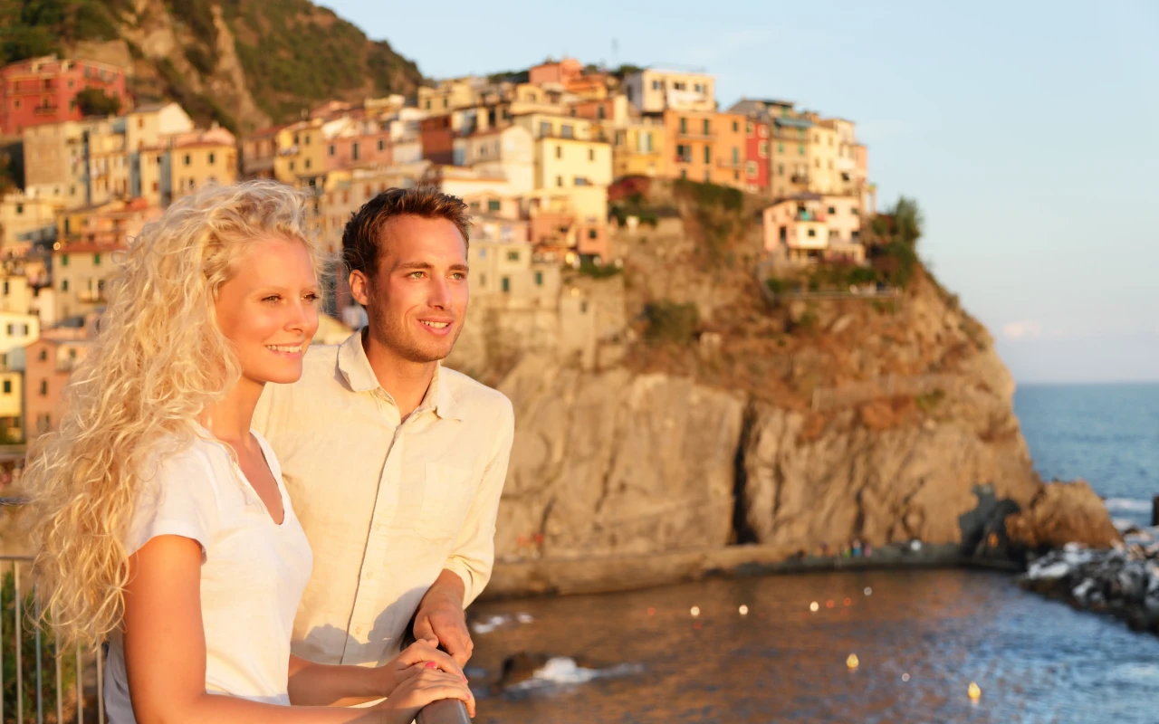 Couple enjoying a romantic sunset over the colorful coastal villages of Cinque Terre, Italy