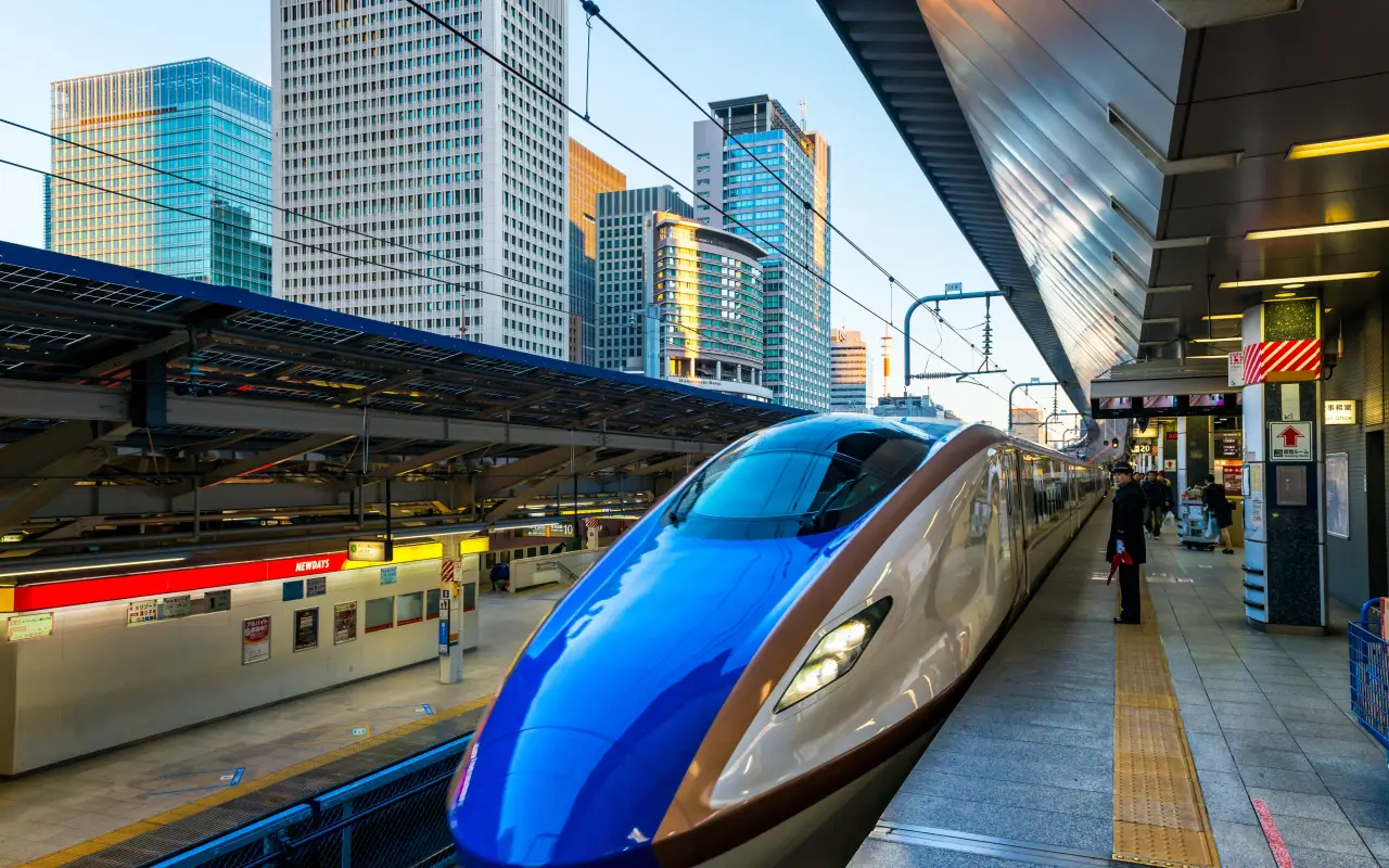 Shinkansen train at a Tokyo station with modern skyscrapers