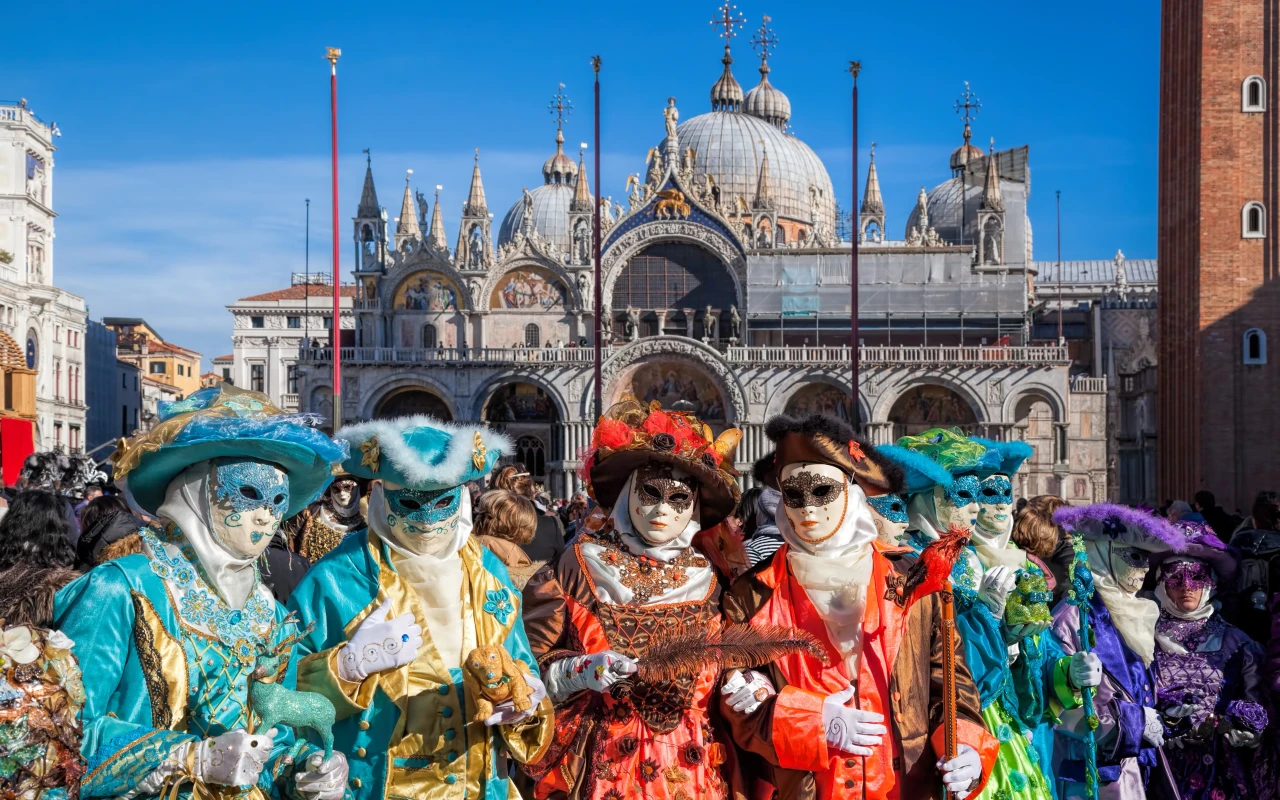 Group of people in traditional masks during Venice Carnival at Saint Marks Square