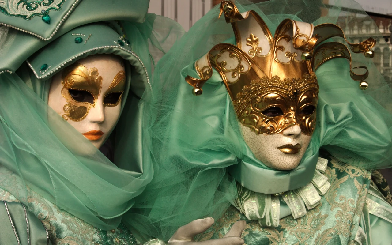 Participants wearing elaborate, colorful masks at the Venice Carnival