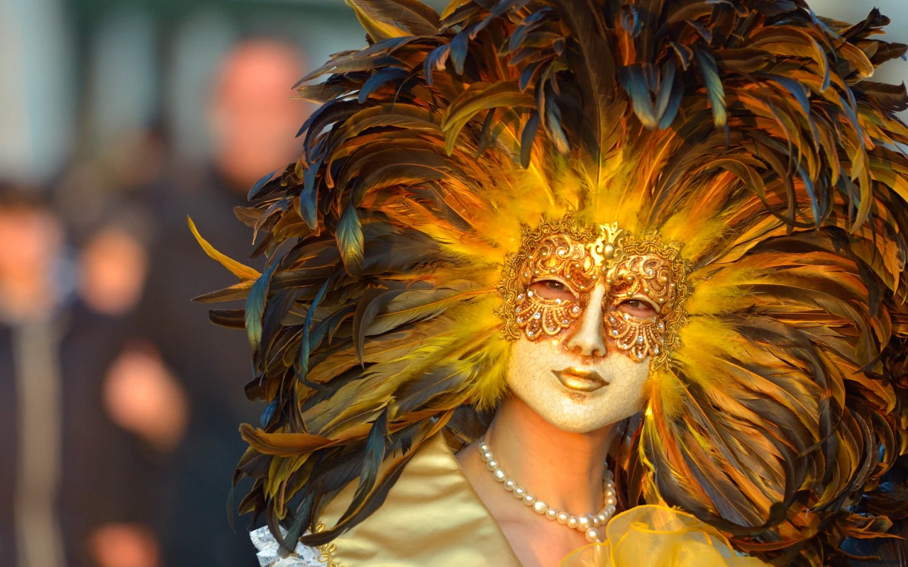 A woman elegantly dressed in traditional Venice Carnival attire, showcasing a stunningly artistic and vibrantly colorful mask.