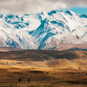 Scenic view of Aoraki Mount Cook National Park with snow-capped peaks and lush greenery