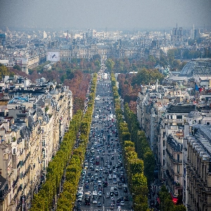 People strolling on the Champs Elysees, Paris, with the iconic Arc de Triomphe in the background