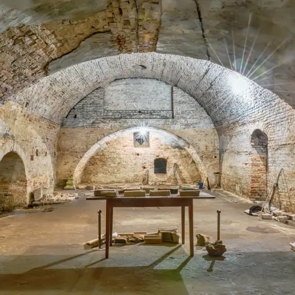 Underground tunnels of the ancient Catacombs of Rome, featuring labyrinthine passageways and tombs