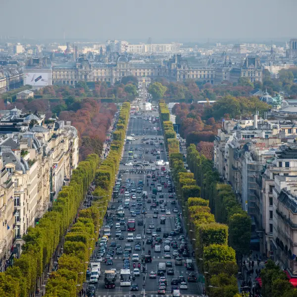 People strolling on the Champs Elysees, Paris, with the iconic Arc de Triomphe in the background