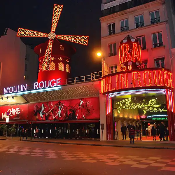 A vibrant image of Moulin Rouge, the iconic Parisian cabaret, with its red windmill and lively atmosphere