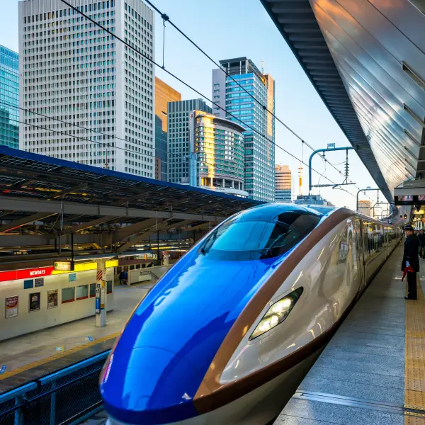 Shinkansen train at a Tokyo station with modern skyscrapers
